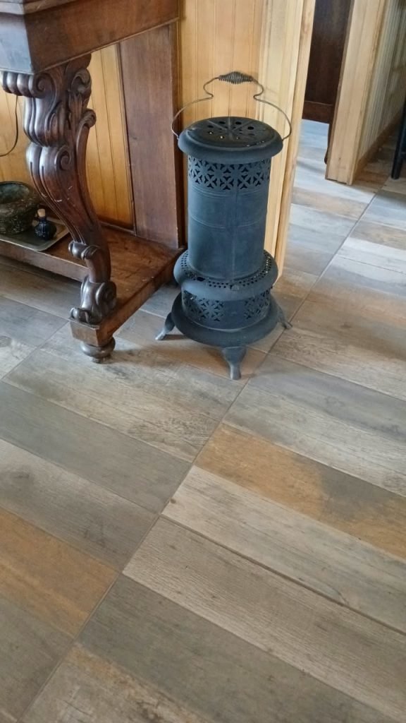 Estufa a parafina antigua junto a consola tallada