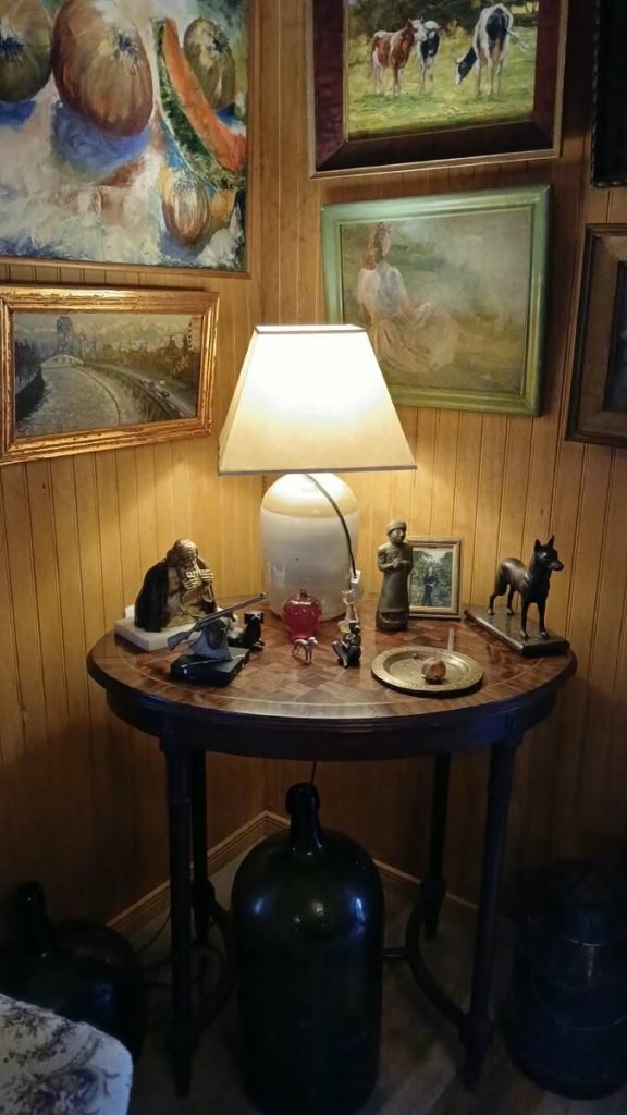 Mesa con figuras de bronce y óleos
